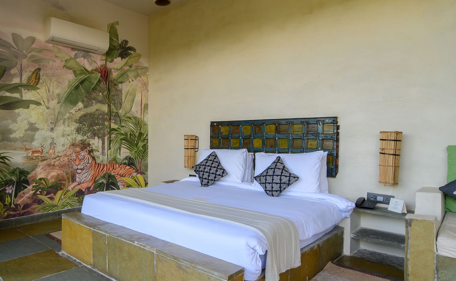 An image of a room with a queen size bed, chandelier, ceiling fan and other decorative items - Utsav Camp Sariska