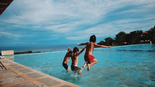 stock image of a group of kids jumping into the swimming pool