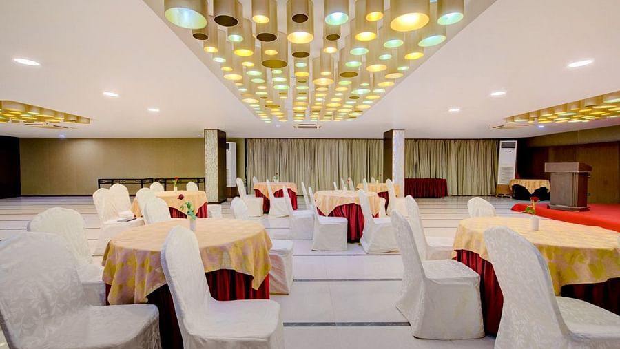 Elegant banquet setup with round tables and white chair covers at Voyage Milestone Hotel and Banquet Siliguri