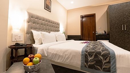 Elegant room with a bed, fruit bowl on the bedside table, and tufted headboard at The Verda de Miranda Resort.