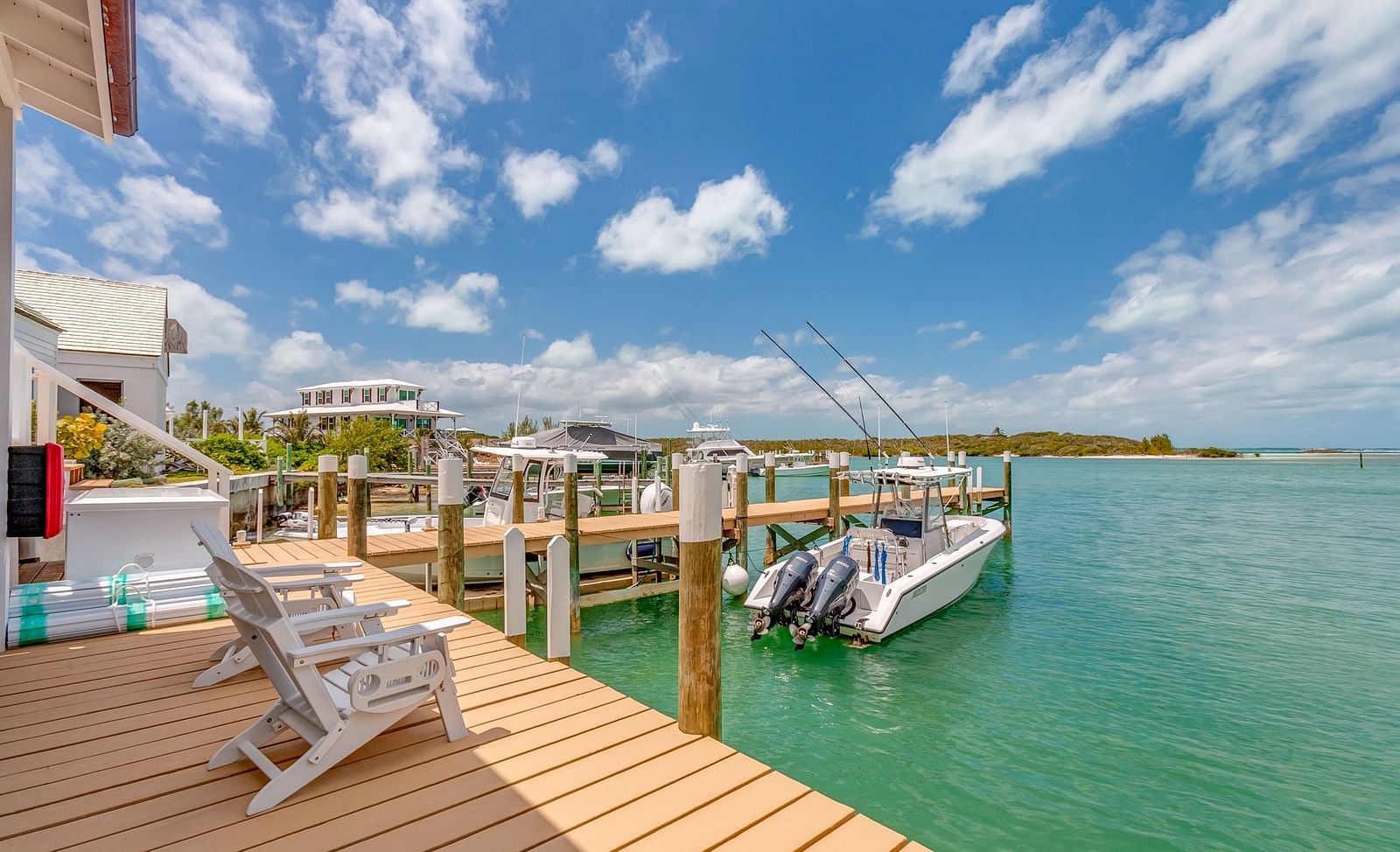 Scenic view of a wooden pier leading to a dock with boats anchored nearby | Abaco Inn