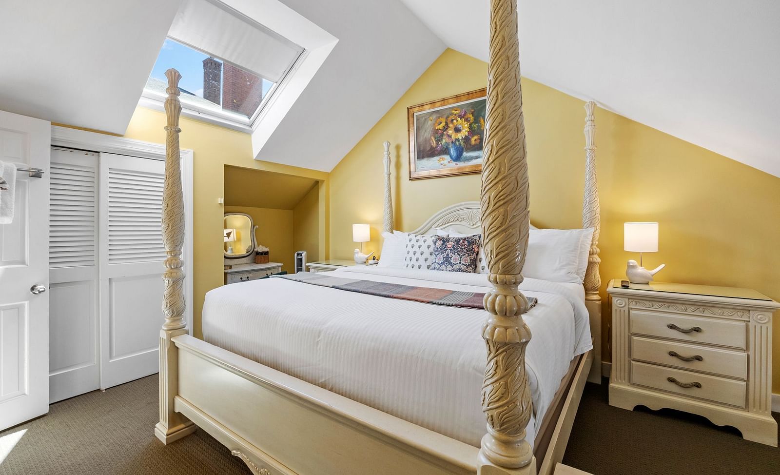 A room featuring a four-poster bed, skylight, and yellow walls at Hartstone Inn