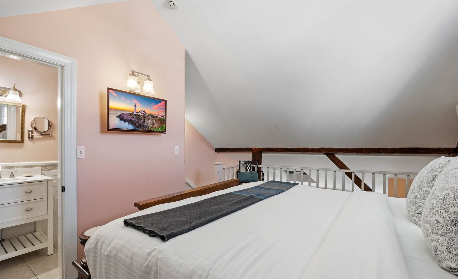 A room with sloped ceiling, compact vanity, and neutral decor at Hartstone Inn