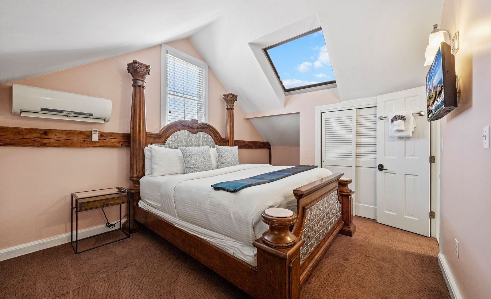 A bedroom with four-poster bed, flat screen TV, and traditional furnishings at Hartstone Inn