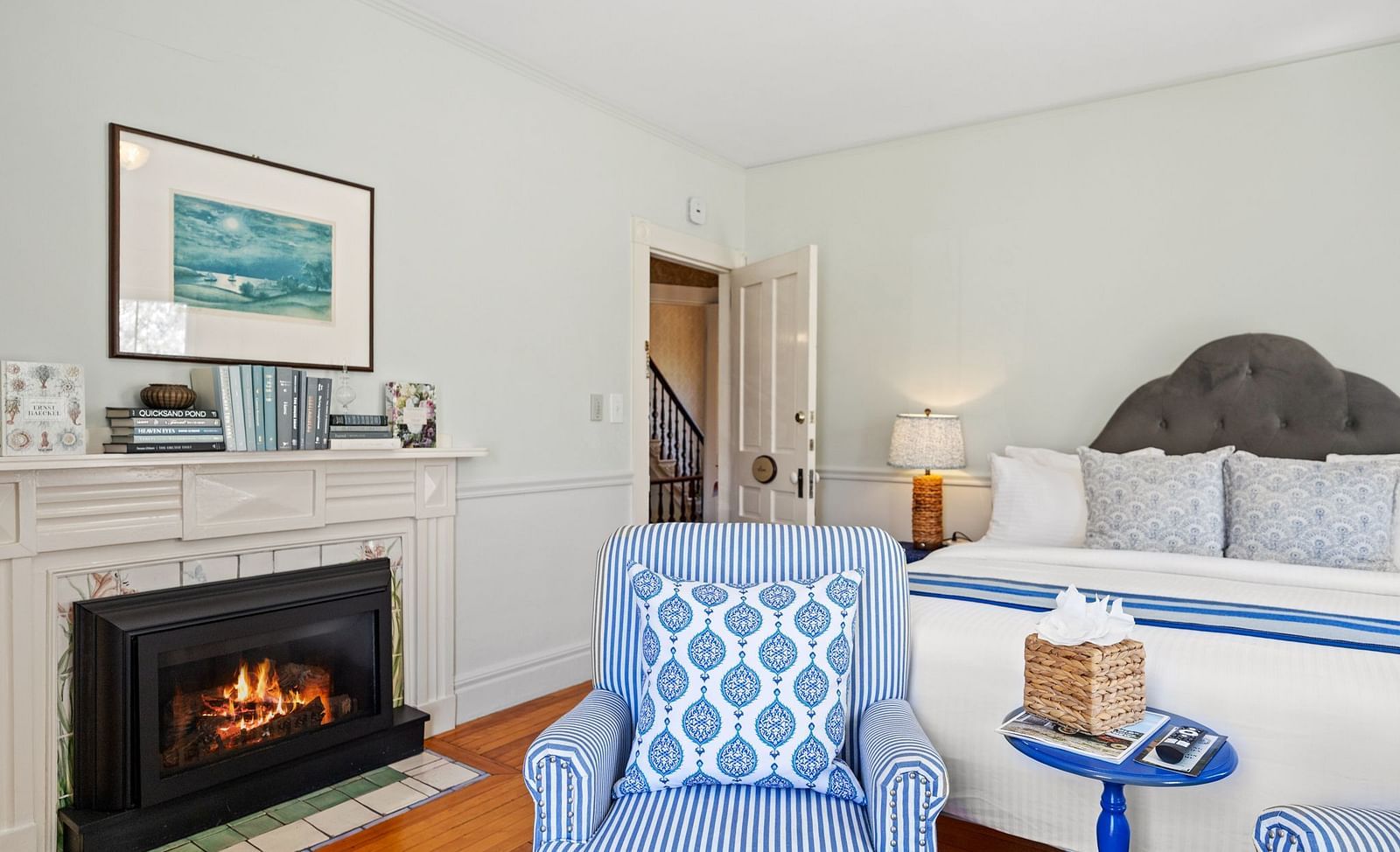 Bedroom with fireplace, two armchairs, and bed at Hartstone Inn.