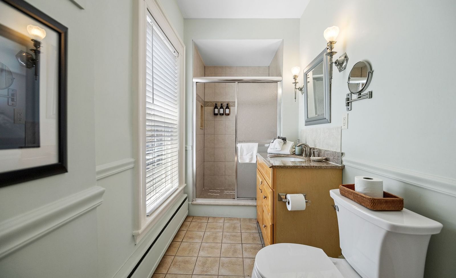 Narrow bathroom with sink, toilet, a small shower area and wall mirror at Hartstone Inn