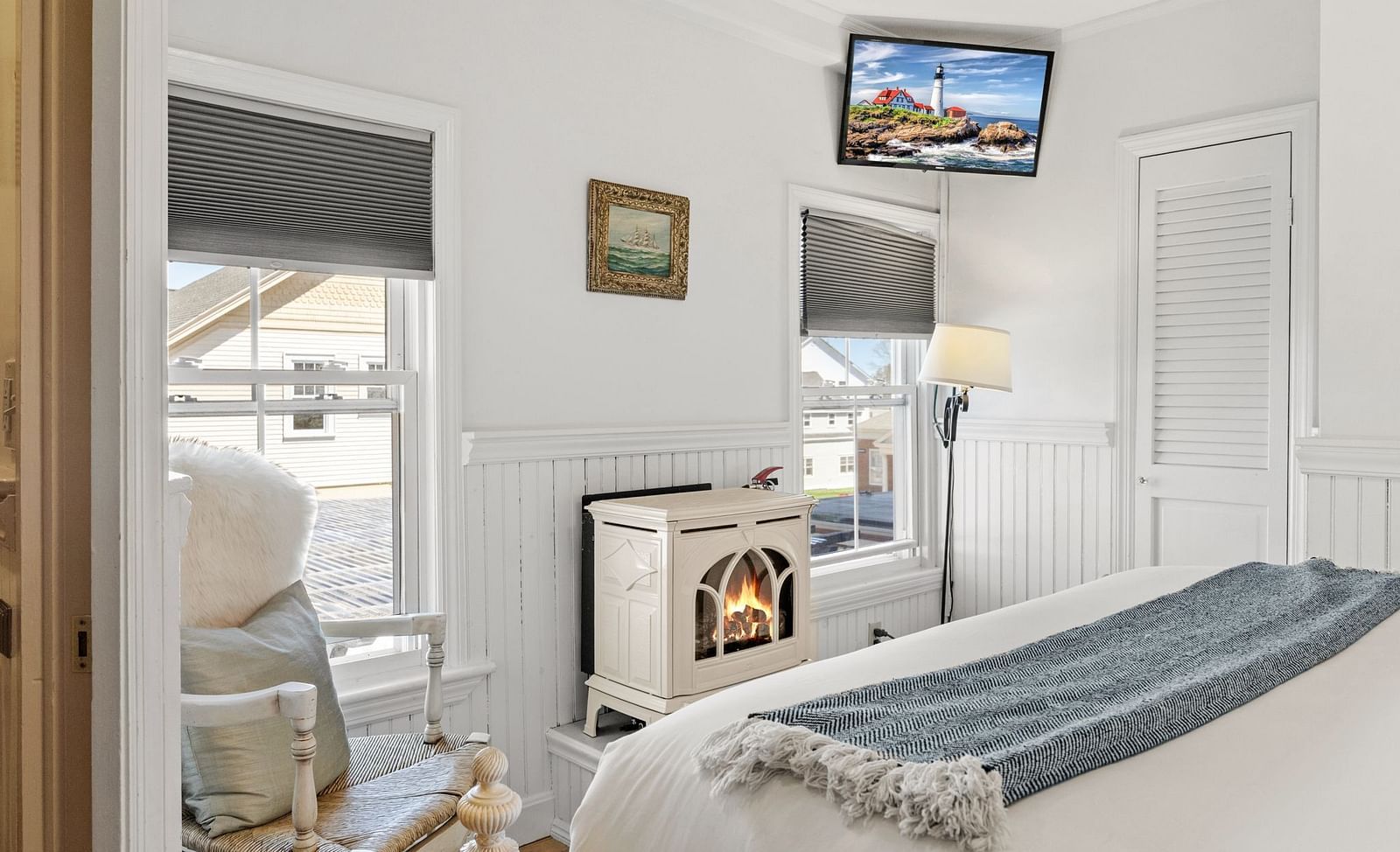 Room with fireplace, modern chair, and TV mounted above at Hartstone Inn