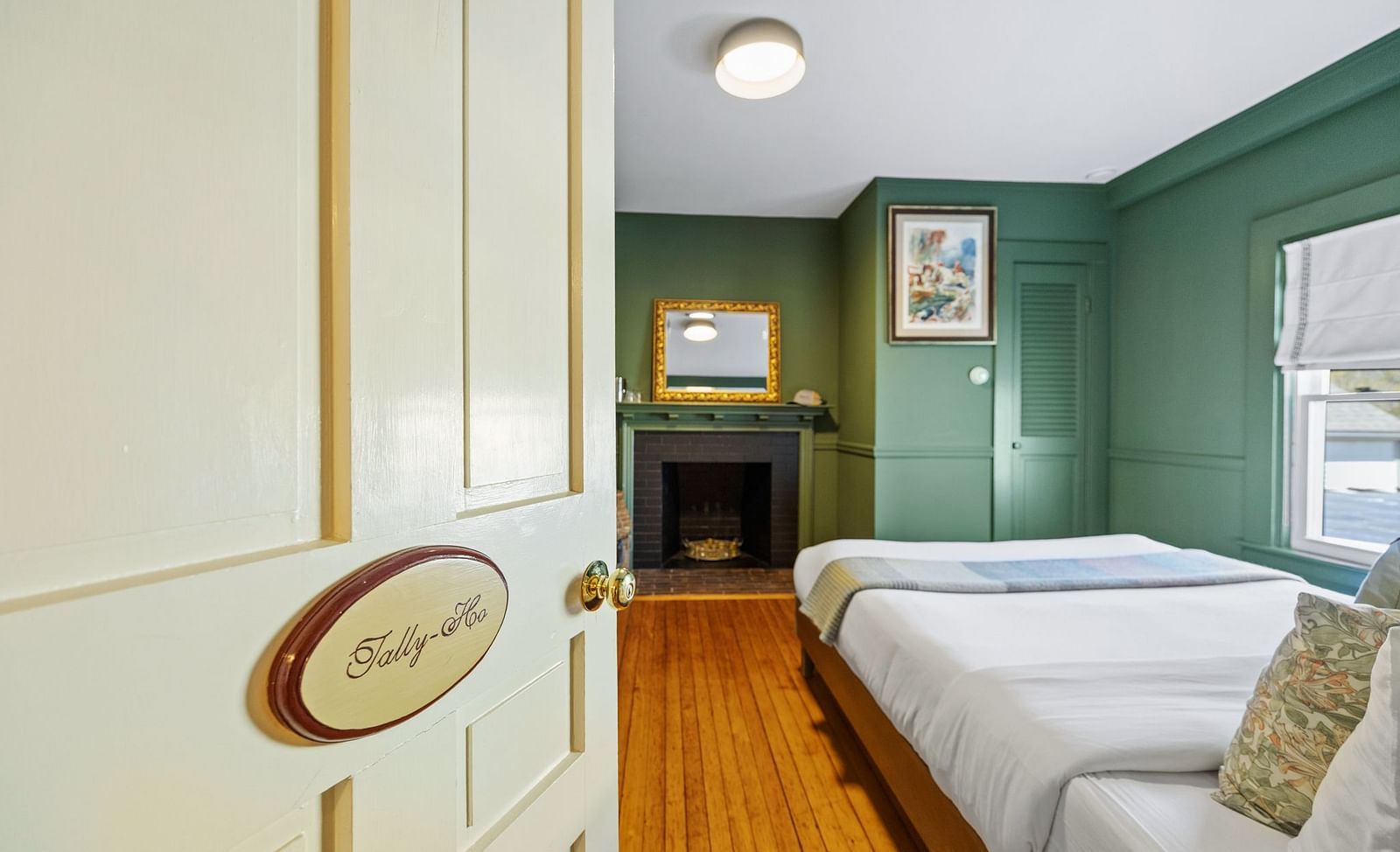 A room entry labelled 'Tally-Hoo' with view into bedroom featuring green walls and bed at Hartstone Inn.