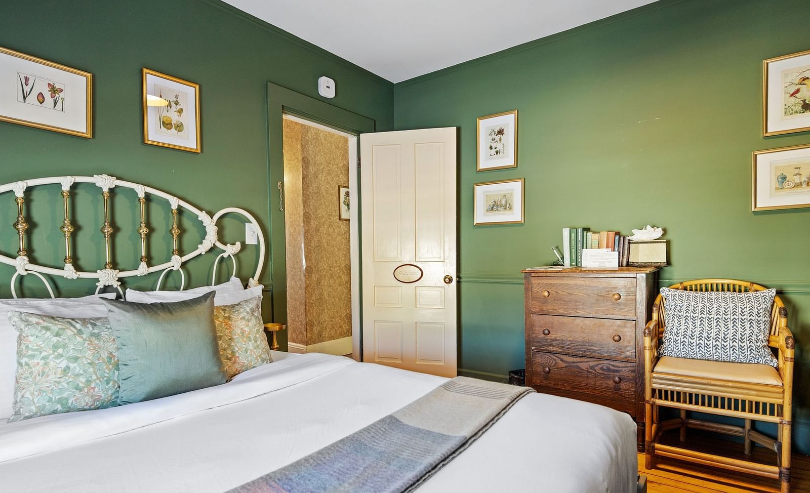 Green-themed bedroom with antique furniture and metal bed frame at Hartstone In