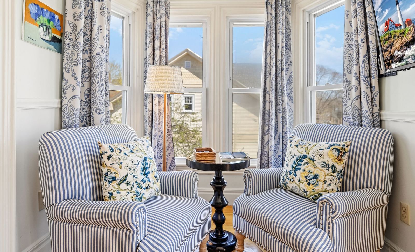 Two striped chairs and a table by large windows at Hartstone Inn