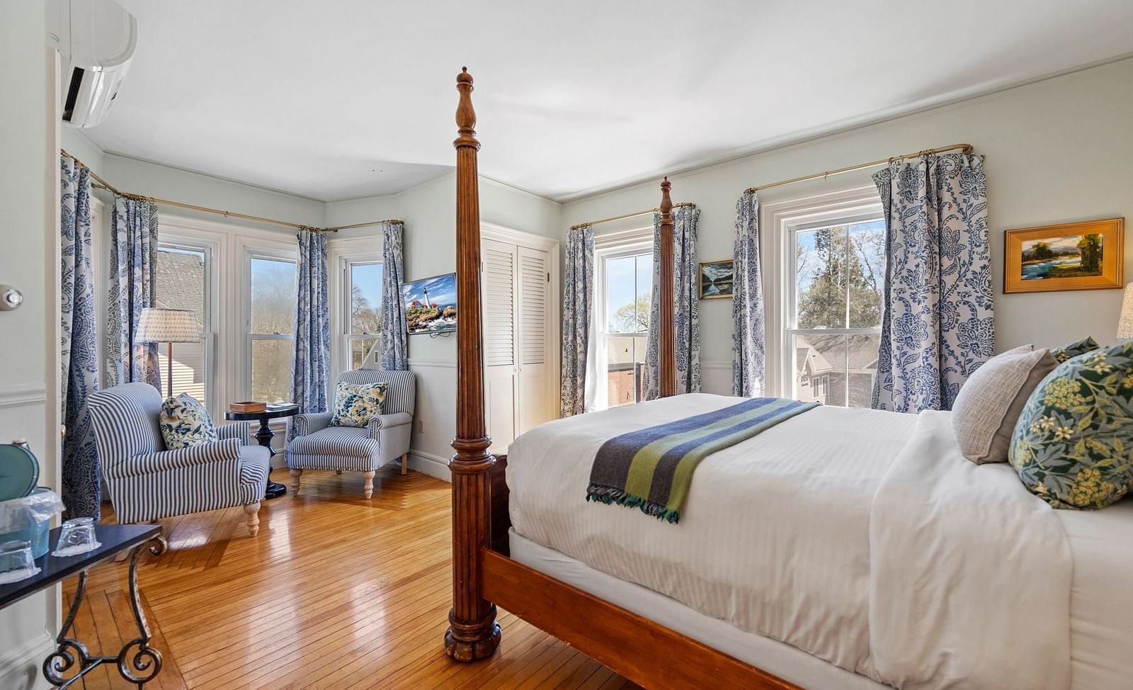 Elegant room with glass windows and dark wood four-poster bed at Hartstone Inn