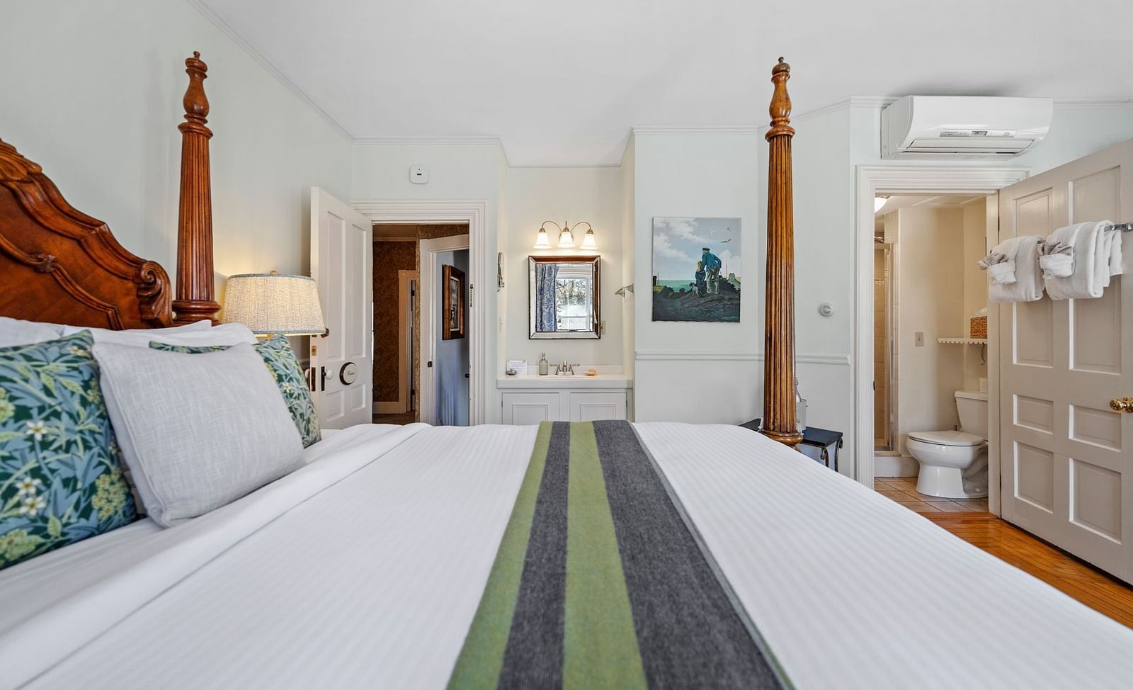 Spacious bedroom with wooden four-poster bed and green runner at Hartstone Inn.