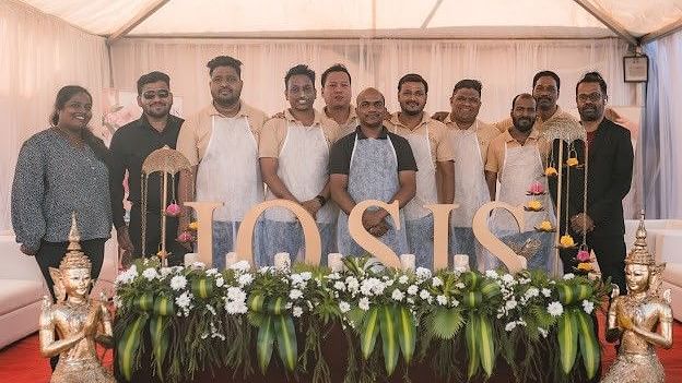 Group of people standing in front of IOSIS logo