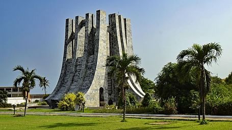 Kwame Nkrumah Mausoleum in Accra, Ghana, with palm trees and manicured lawns under a clear blue sky.