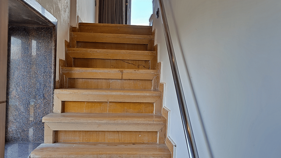 Wooden staircase leading to an upper level with a handrail
