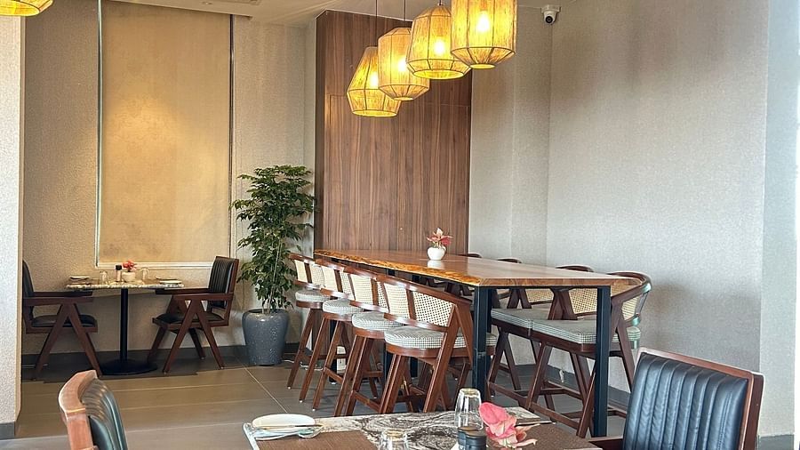 Seating arrangement inside the restaurant with chandelier above it - Rhythm Gurugram