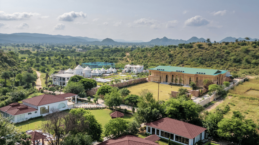 Aerial view of the resort grounds under clear skies at Valley by Grassfield, a wedding resort in Jaipur.