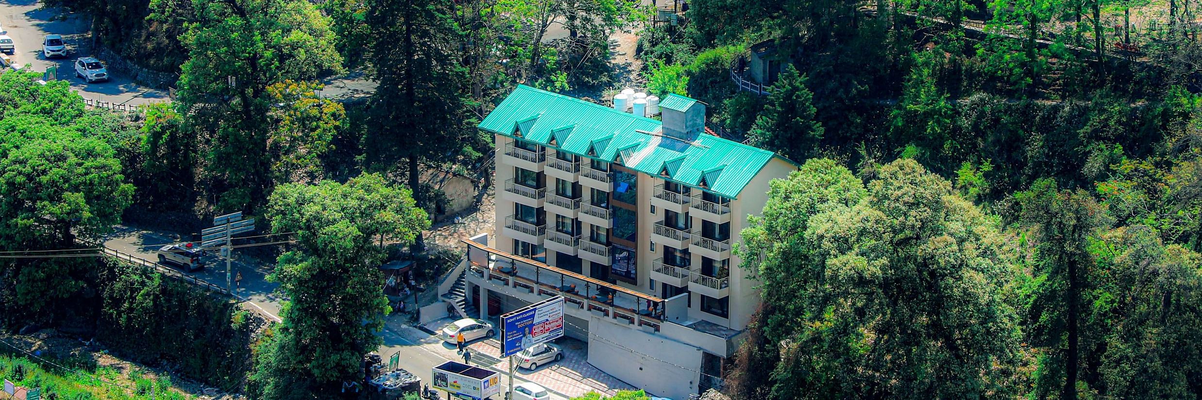 Outdoor view of Vinsober Monal, Nainital, nestled amidst a verdant embrace of lush green trees               