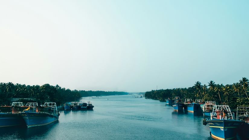 Boats moored along a peaceful river flanked by lush greenery