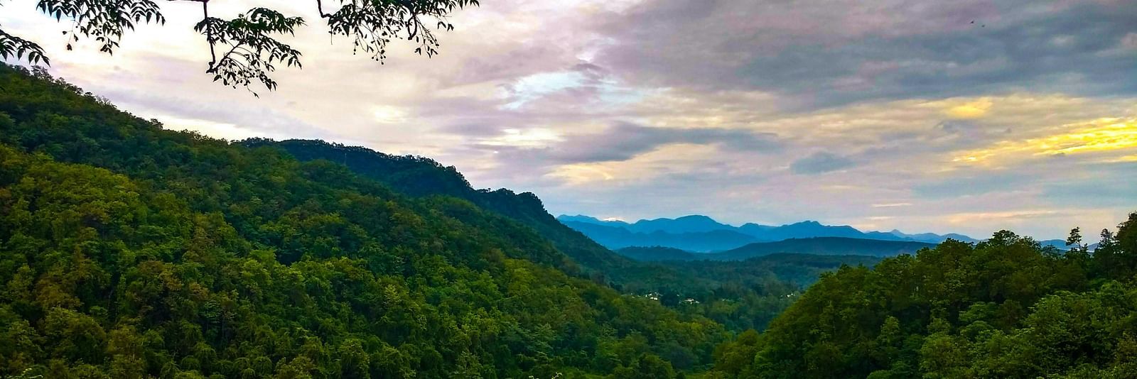 a mesmerising landscape of dehradun with a beautiful sky with clouds in the background