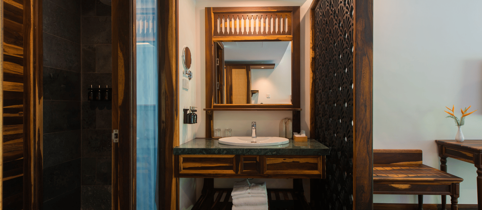 Bathroom in Balcony Room at Alibu Resort Nha Trang with vanity, mirror, and wood counter.