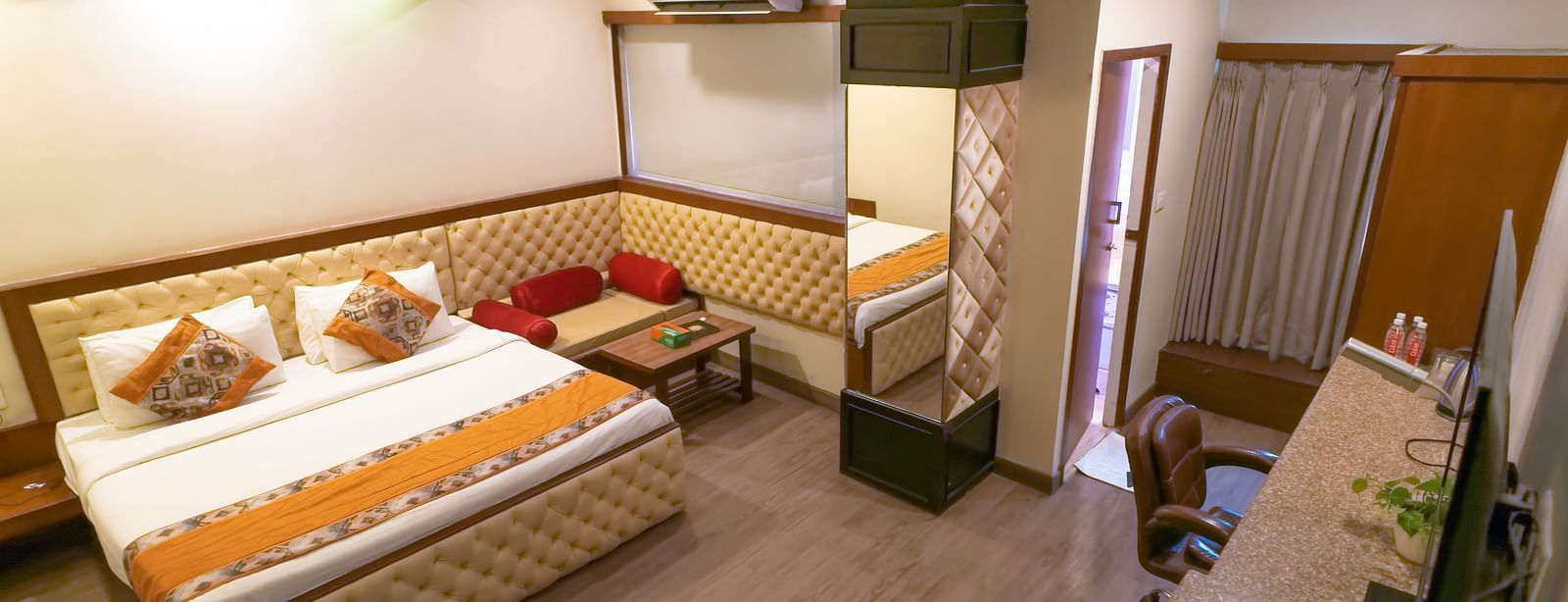 A view of the Deluxe Room featuring a bed with wooden interior at Hotel Ashok Nagpur.