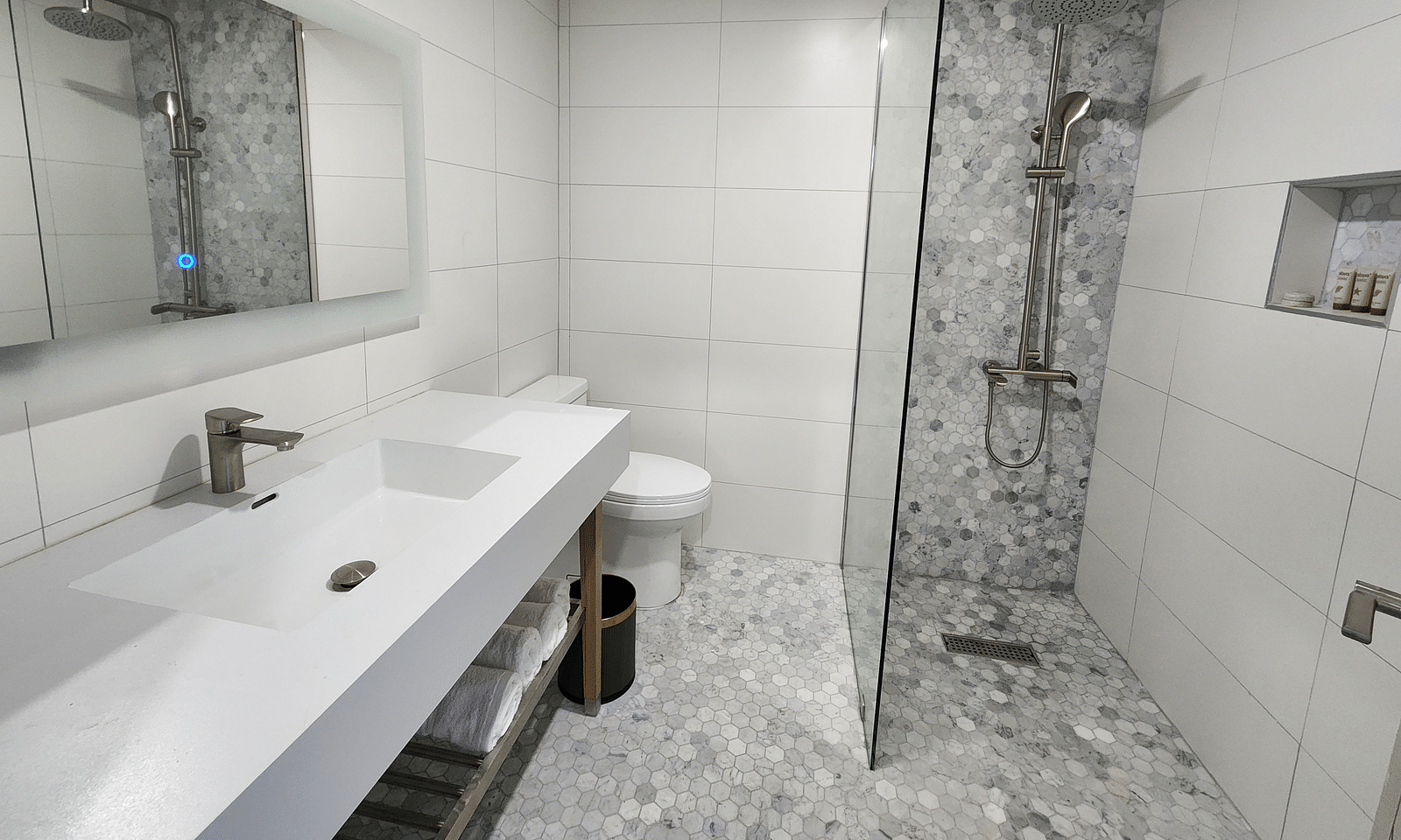 A modern bathroom with sleek white fittings and a glass shower partition - Hotel 39, Jamaica