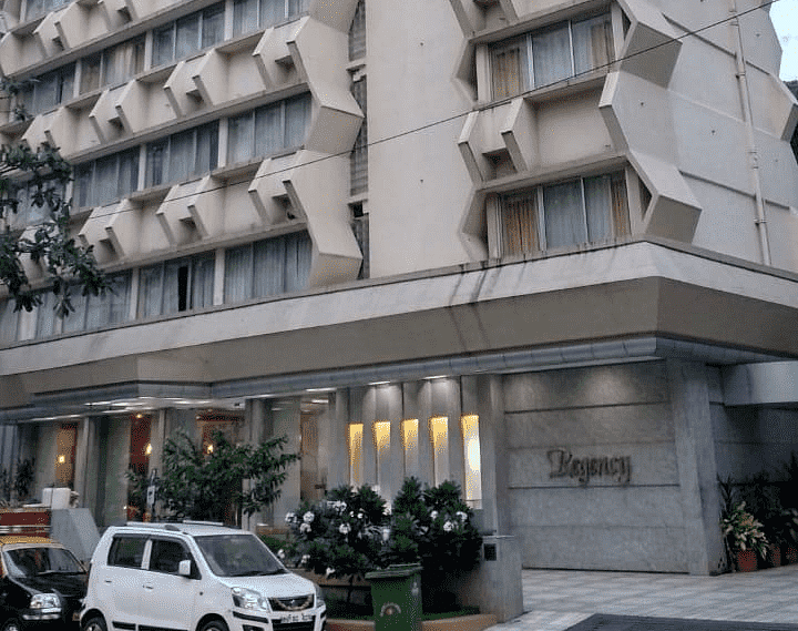 Facade image of Regency Hotel, Mumbai with a car parked outside at the entrance.
