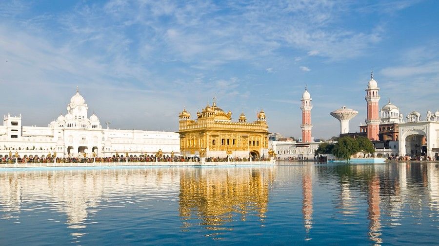 A lake near the Golden Temple in Amritsar. There are also other religious structures near it.