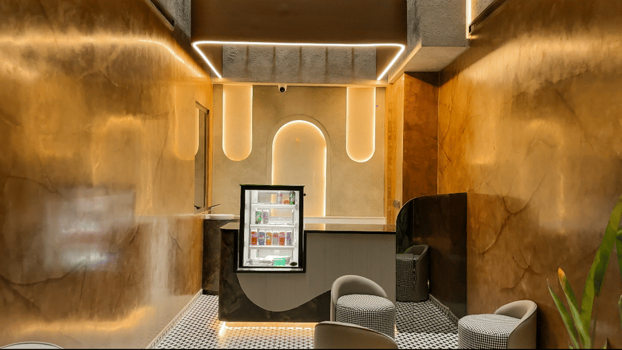 A small counter in a corner at F Hotels, Bengaluru, featuring bright modern interiors along with a small mini fridge.