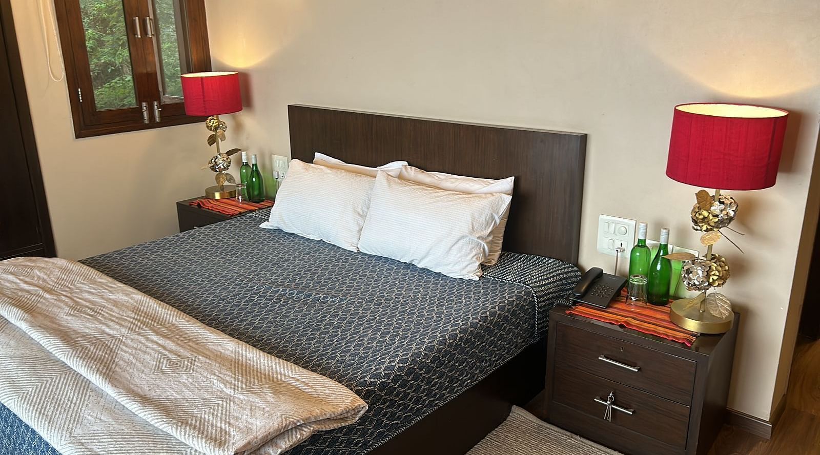 A large bed next to a nightstand in one of the bedrooms in 2BHK at SOUTHGATE KASAULI BY ZENQ.
