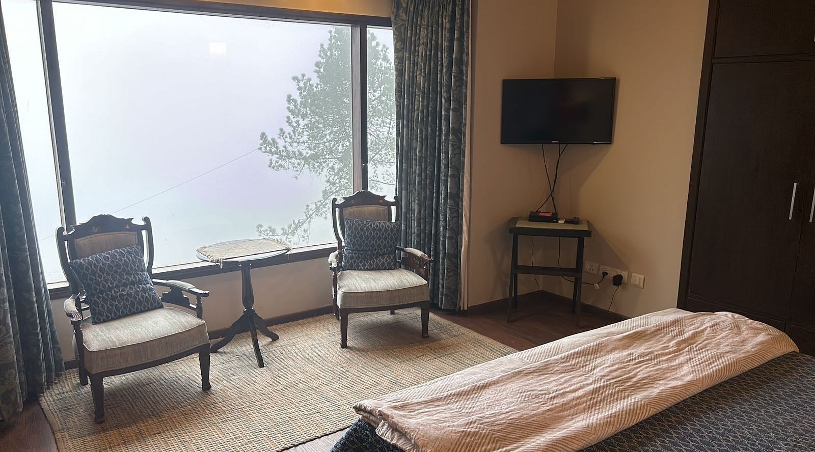 View from the bed of two chairs  near a window at 2 BHK at SOUTHGATE KASAULI BY ZENQ