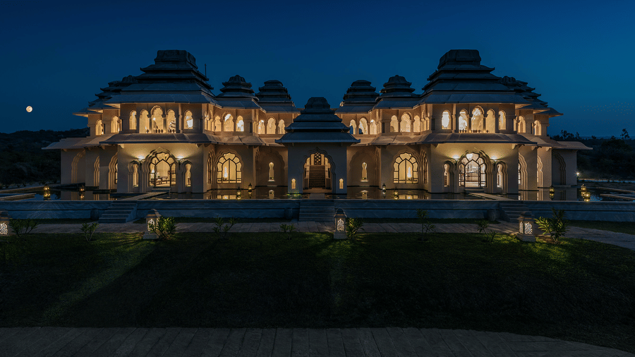 Grand illuminated facade of Evolve Back Hampi resort at night