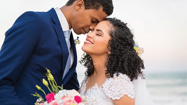 A couple in wedding attire standing in front of a beach - S Hotel Montego Bay, Jamaica