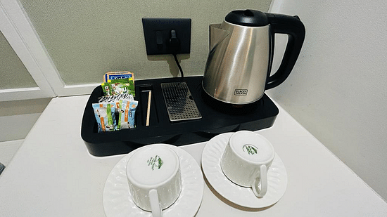 An image showcasing a kettle, cups, plates and packets of tea and coffee - Five Elements Hotels Goldleaf, Haldwani
