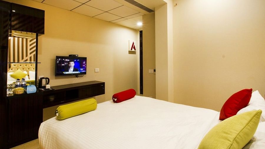 Standard room with bed and television on the wall at Art Boutique Hotel, Hyderabad