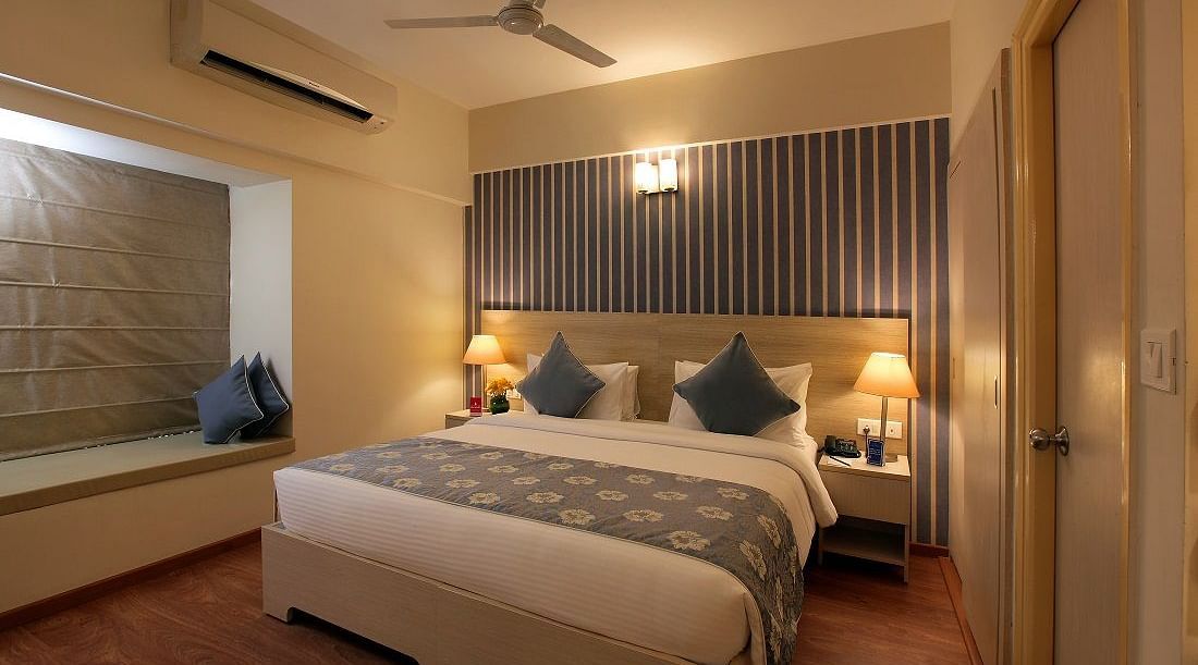 Deluxe room at Starlit Suites, Bangalore with a double bed and side tables