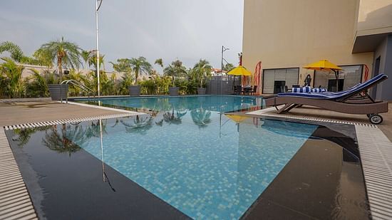 a view of the swimming pool at suite room at Ramada by Wyndham Kapurthala surrounded by trees