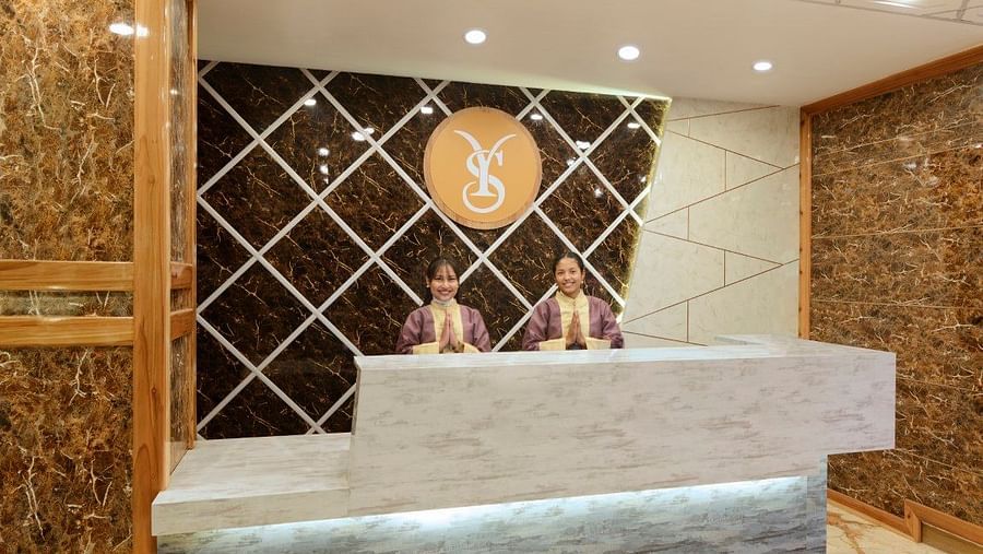 An image of the reception area where Two women are greetings with their hands folded - Yashshree Sikkim Blossom, Gangtok