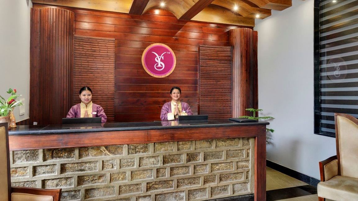 Reception of Sumitel Queensyard where two women are greeting with their hands folded