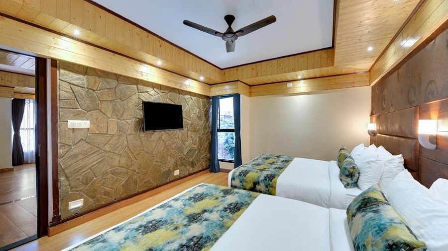 An image of Sumitel Queensyard premium room with king size bed, tv, ceiling fan, and minimal decoration