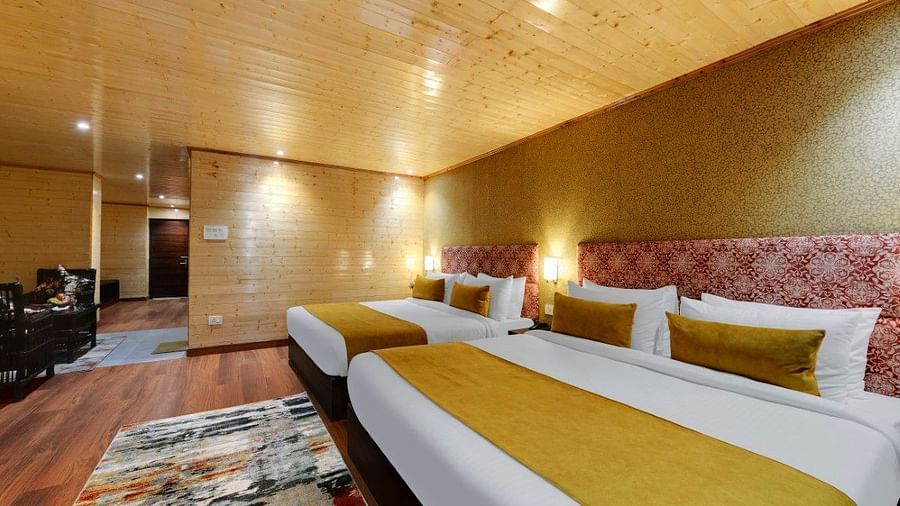 Image of two king size bed in a expansive room with a yellow blanket and wooden furnishing | Yashshree Lachung