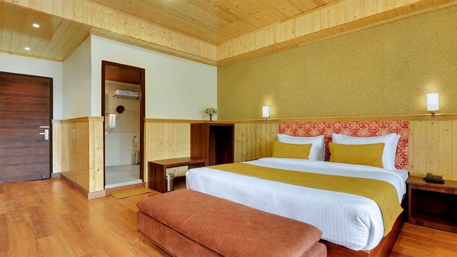 Shot of a premium room at our hotel that features a king size bed, two bed side lamp, a couch  | Yashshree Lachung