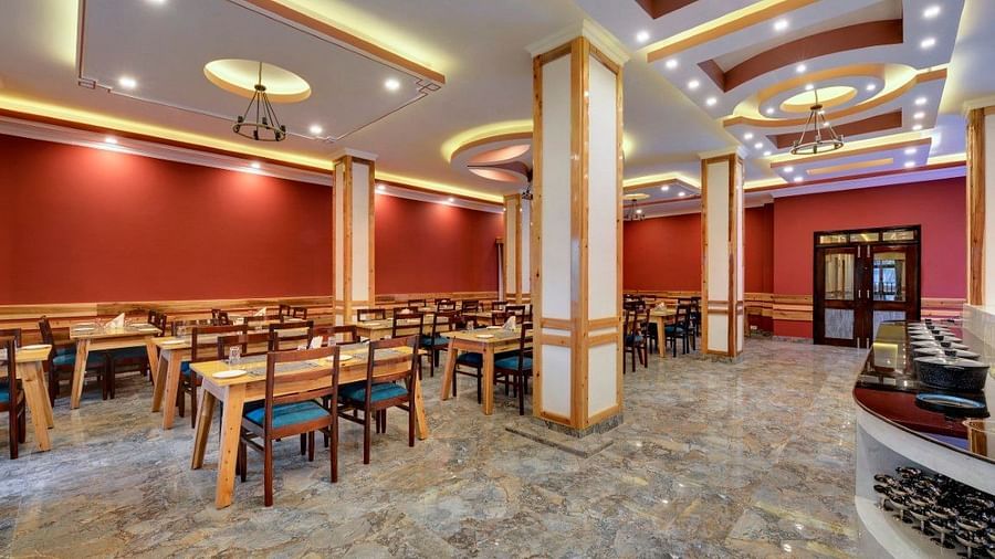 AN image of a restaurant with chairs and tables and warm lighting - Yashshree Sikkim Blossom, Gangtok