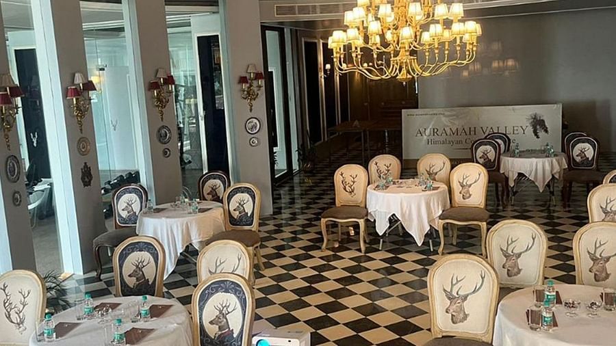  Chic dining room at The Manor Sports & Wellness Hotel with black-and-white flooring, classic chandeliers, and elegant deer-themed chairs set for a refined experience.