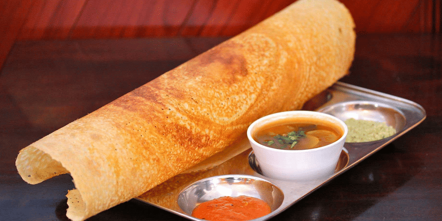 The south india dish dosa, sambar and chutney served on the plate.