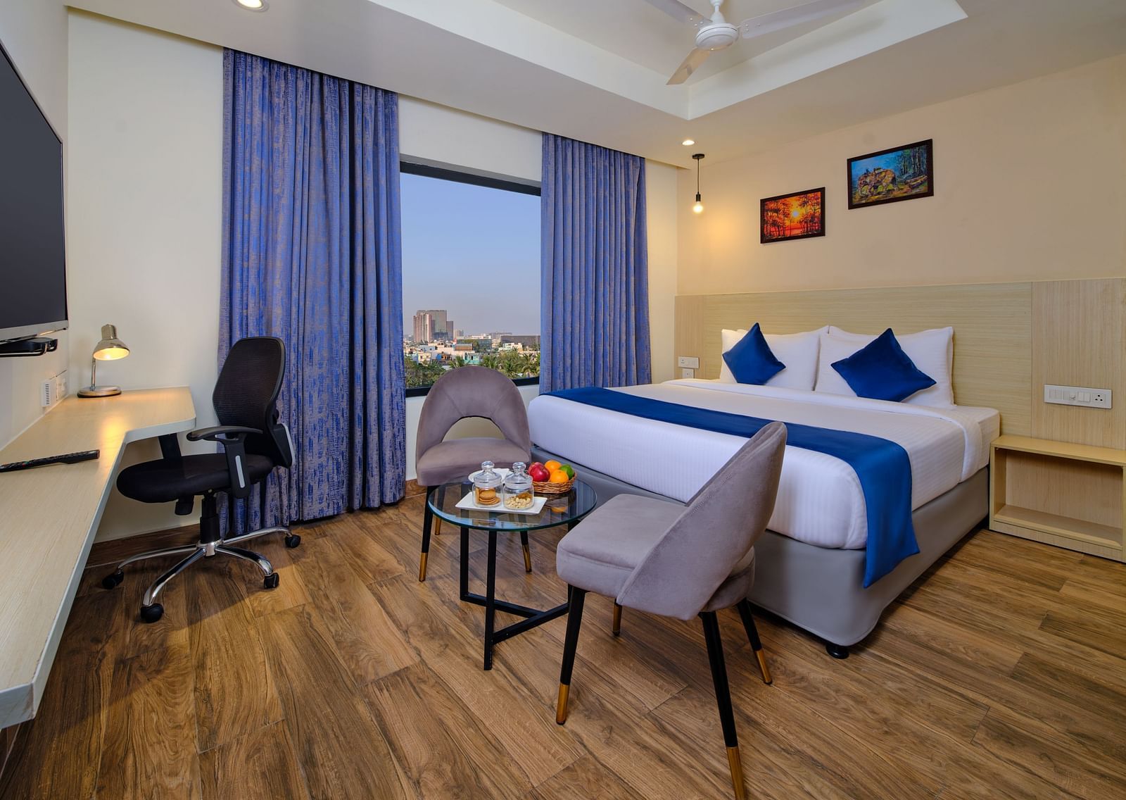 A room at Essentia Premier Hotel, Chennai with a double bed, a television and a work desk and chair