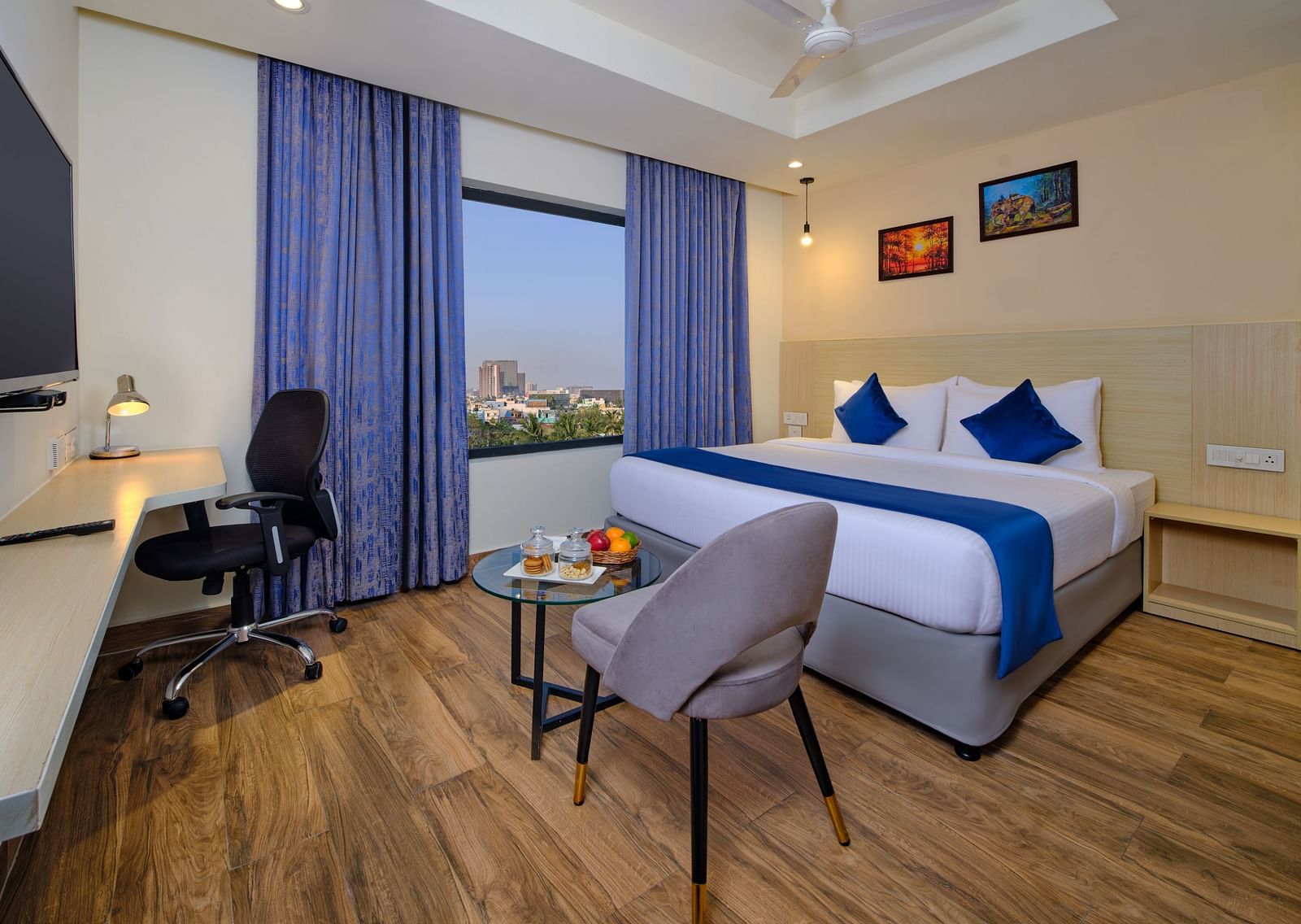 A room at Essentia Premier Hotel, Chennai with a double bed, a television and a work desk and chair