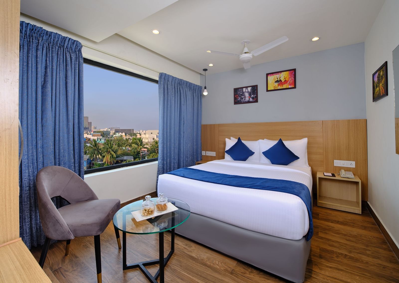 A room at Essentia Premier Hotel, Chennai with a double bed, a television and a work desk and chair.