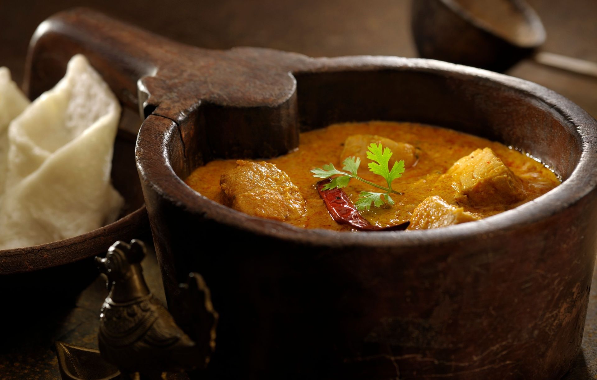 Kerala Fish Curry in a traditional wooden bowl.